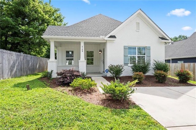 2109 Freeman St, Winston-Salem, NC 27127 - view of front of home featuring brick siding, covered porch, roof with shingles, and board and batten siding