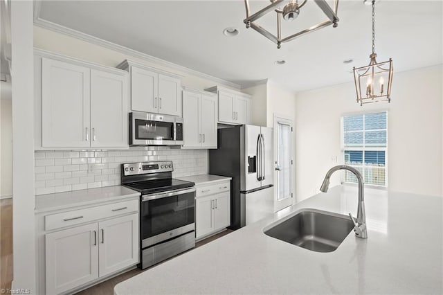 2109 Freeman St, Winston-Salem, NC 27127 - kitchen featuring appliances with stainless steel finishes, a chandelier, light countertops, decorative light fixtures, and tasteful backsplash