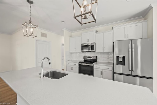 2109 Freeman St, Winston-Salem, NC 27127 - kitchen with appliances with stainless steel finishes, a chandelier, ornamental molding, white cabinets, and light countertops