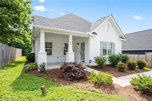 2109 Freeman St, Winston-Salem, NC 27127 - view of front facade featuring roof with shingles, a porch, brick siding, and board and batten siding