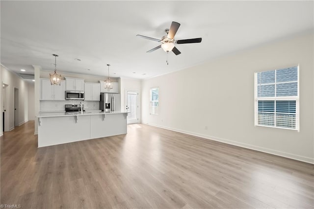 2109 Freeman St, Winston-Salem, NC 27127 - unfurnished living room featuring light wood-style flooring, ceiling fan, and crown molding
