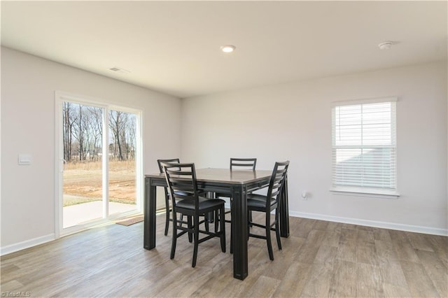 dining space featuring baseboards and wood finished floors