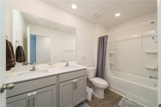 full bathroom featuring double vanity, visible vents, toilet, and a sink