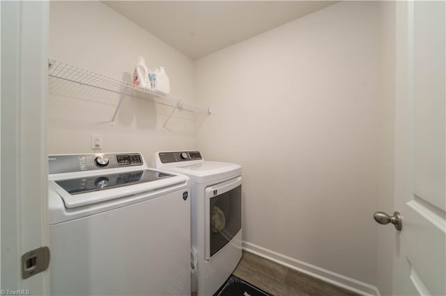 washroom with baseboards, dark wood finished floors, laundry area, and washer and clothes dryer