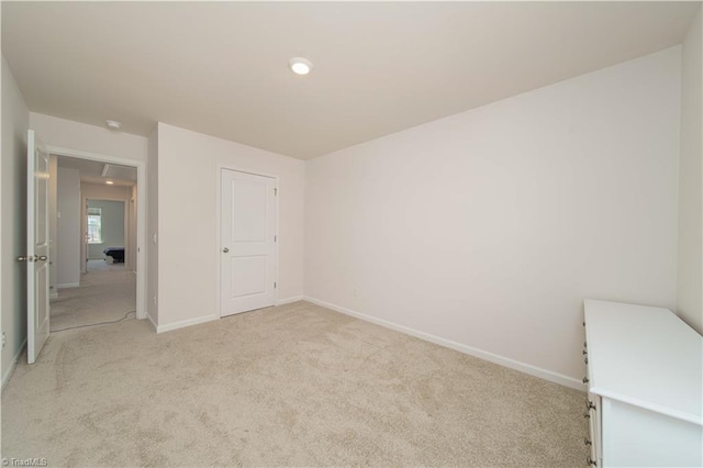 unfurnished bedroom featuring light colored carpet and baseboards