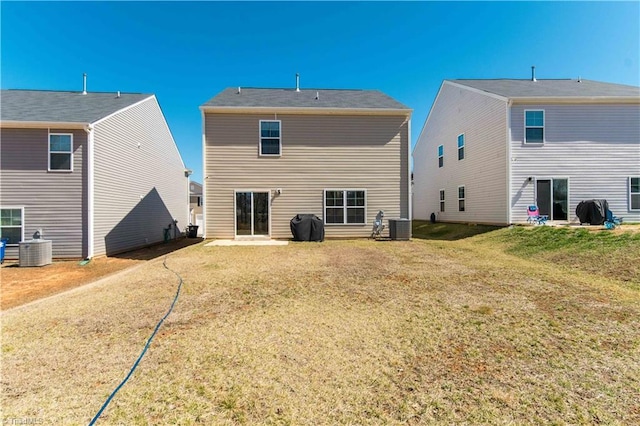 back of house featuring central AC unit and a lawn