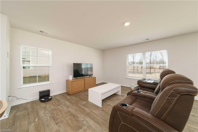 living area with recessed lighting, baseboards, visible vents, and light wood finished floors