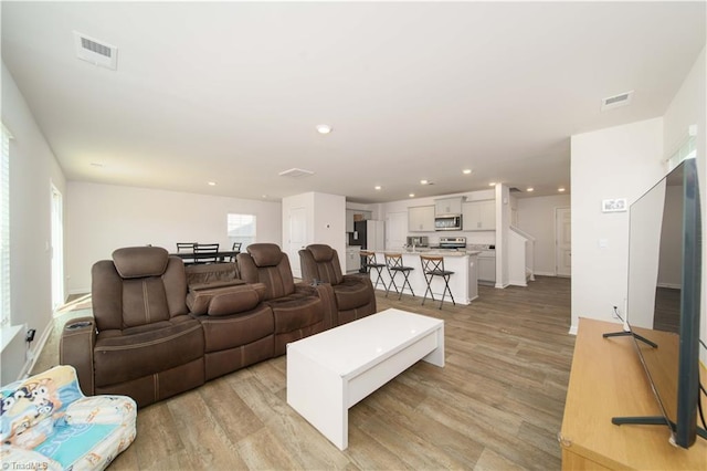 living room with visible vents, recessed lighting, and light wood-type flooring