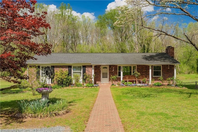 view of front of house featuring a front lawn, brick siding, and a chimney