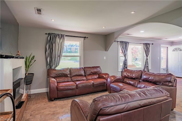 living area with arched walkways, visible vents, a wealth of natural light, and recessed lighting