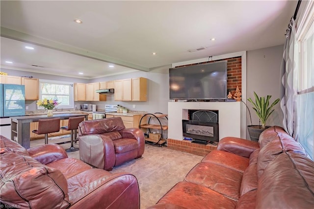 living room featuring a brick fireplace, visible vents, and recessed lighting