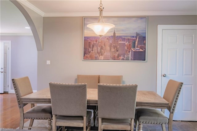 dining space featuring arched walkways and ornamental molding