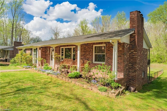 single story home with a chimney, brick siding, and a front yard