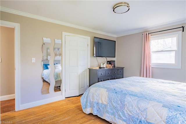 bedroom featuring light wood-type flooring, baseboards, and ornamental molding