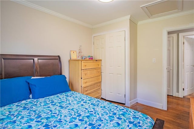 bedroom featuring attic access, baseboards, ornamental molding, and wood finished floors