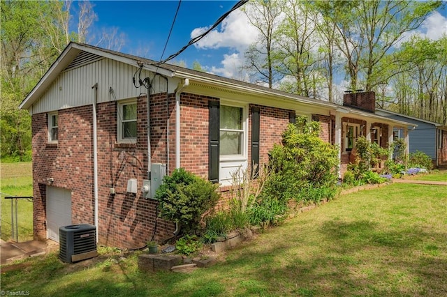 view of side of home featuring brick siding, a yard, cooling unit, and a garage