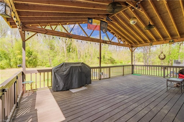 wooden deck with a ceiling fan and area for grilling