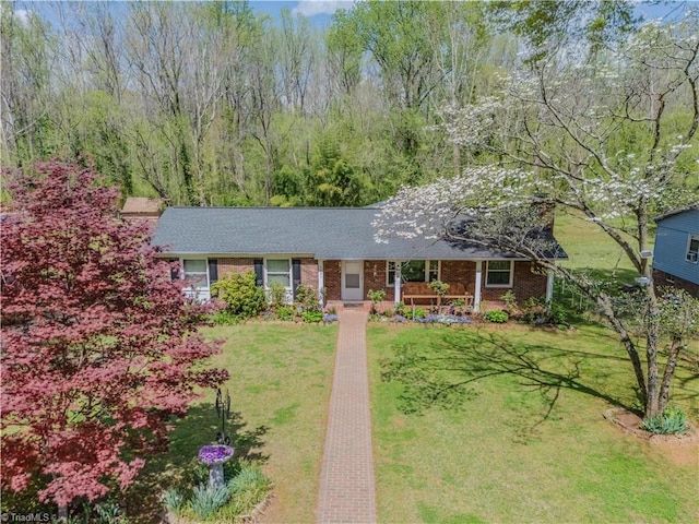 ranch-style house featuring a front lawn, brick siding, and a porch