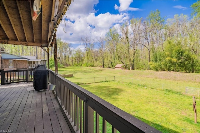 deck with grilling area, a lawn, and fence