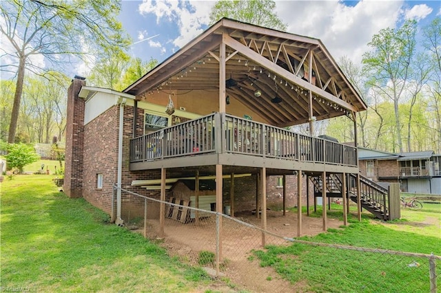 back of house with a wooden deck, a lawn, a chimney, and stairway
