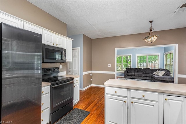 1515 Klompen Rd, Kernersville, NC 27284 - kitchen featuring stainless steel refrigerator, black electric range, light countertops, white cabinetry, and a textured ceiling