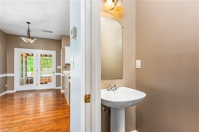 1515 Klompen Rd, Kernersville, NC 27284 - bathroom featuring wood finished floors, baseboards, a sink, and a textured ceiling