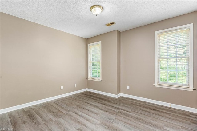 1515 Klompen Rd, Kernersville, NC 27284 - spare room featuring plenty of natural light, wood finished floors, a textured ceiling, and baseboards