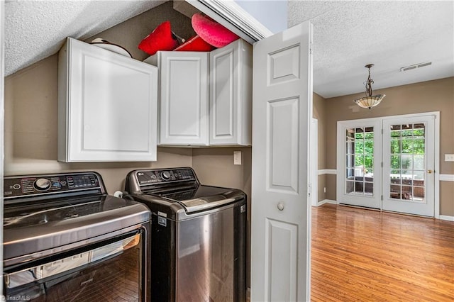 1515 Klompen Rd, Kernersville, NC 27284 - washroom with cabinet space, a textured ceiling, washing machine and clothes dryer, light wood-type flooring, and baseboards