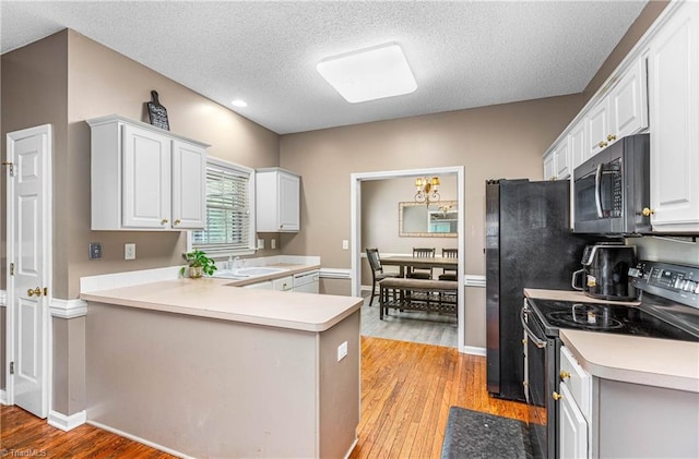 1515 Klompen Rd, Kernersville, NC 27284 - kitchen featuring stainless steel microwave, electric range oven, light wood-style flooring, dishwasher, and a textured ceiling
