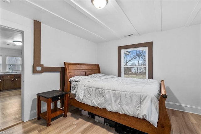 bedroom with light hardwood / wood-style flooring and sink