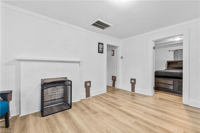 living room with light hardwood / wood-style flooring and crown molding