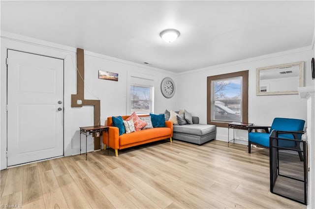 living room with light wood-type flooring and ornamental molding