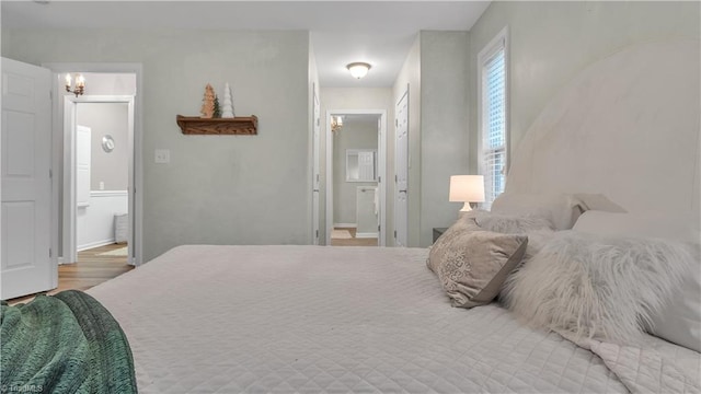 bedroom with light wood-type flooring and ensuite bath