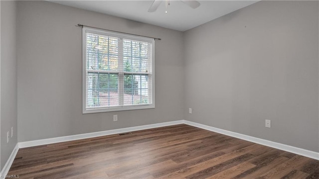 spare room featuring a wealth of natural light, dark wood-type flooring, and ceiling fan