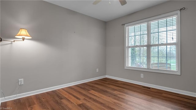 unfurnished room featuring wood-type flooring, a wealth of natural light, and ceiling fan