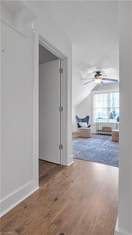 corridor featuring hardwood / wood-style floors and vaulted ceiling