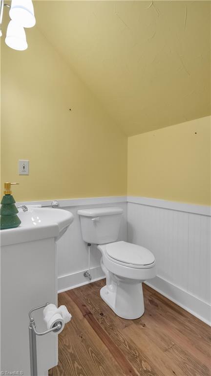 bathroom featuring toilet, lofted ceiling, and hardwood / wood-style flooring