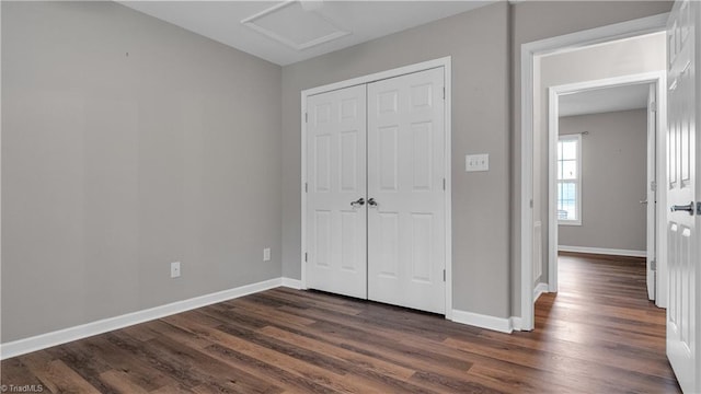 unfurnished bedroom with a closet and dark hardwood / wood-style floors