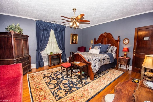 bedroom featuring ornamental molding, a textured ceiling, ceiling fan, and dark wood-type flooring