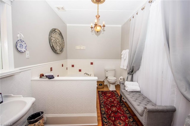 bathroom featuring toilet, a notable chandelier, hardwood / wood-style flooring, and sink