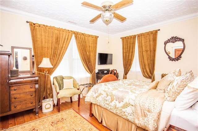 bedroom featuring light hardwood / wood-style floors, ceiling fan, and crown molding