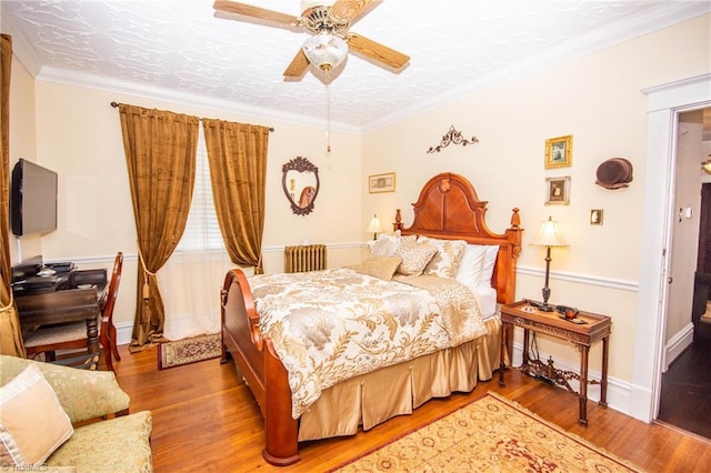 bedroom with ceiling fan, ornamental molding, and wood-type flooring