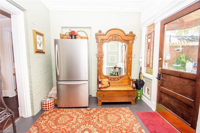 interior space with dark hardwood / wood-style flooring, brick wall, and ornamental molding