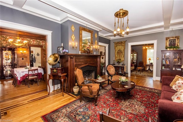 living room featuring crown molding, a notable chandelier, light wood-type flooring, and beam ceiling