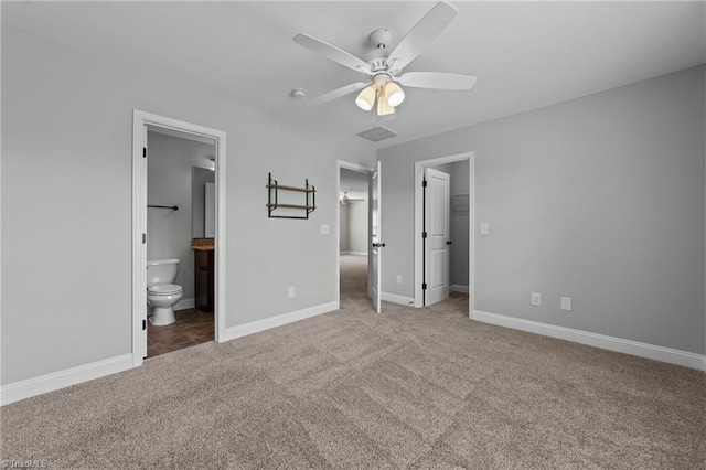 unfurnished bedroom with carpet flooring, a spacious closet, baseboards, connected bathroom, and a closet
