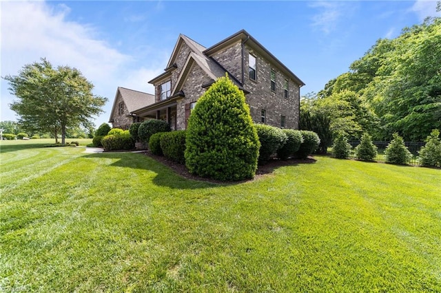 view of side of home with a yard and brick siding