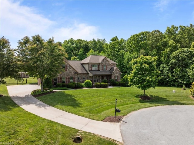view of front of home featuring stone siding and a front lawn