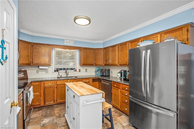 4104 Moss Brook Dr, Winston-Salem, NC 27127 - kitchen with brown cabinetry, a sink, and stainless steel appliances