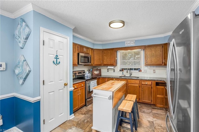 4104 Moss Brook Dr, Winston-Salem, NC 27127 - kitchen with a sink, crown molding, brown cabinets, and appliances with stainless steel finishes