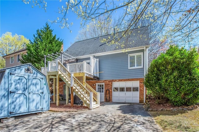 4104 Moss Brook Dr, Winston-Salem, NC 27127 - view of front of home with stairway, an attached garage, driveway, brick siding, and a storage shed